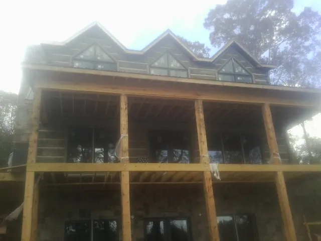 Dormers and porch framing on a large log home under construction — Roof Coating work by our crew in Pottstown
