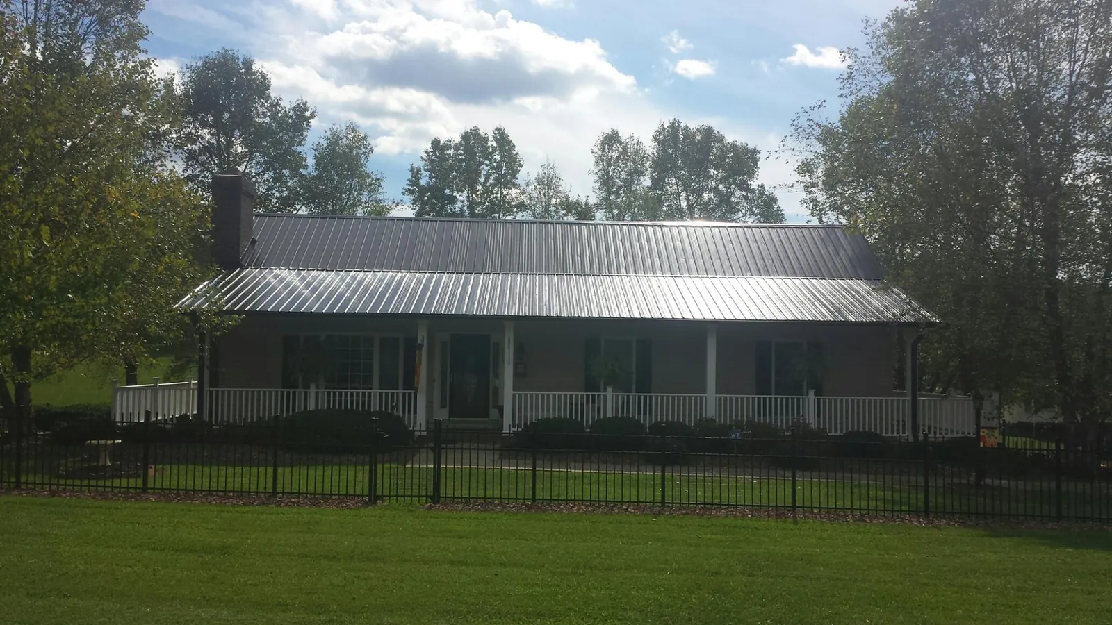 Gray metal roof on a brick ranch with a full width front porch — Gutter Guard Installation work by our crew in Pottstown
