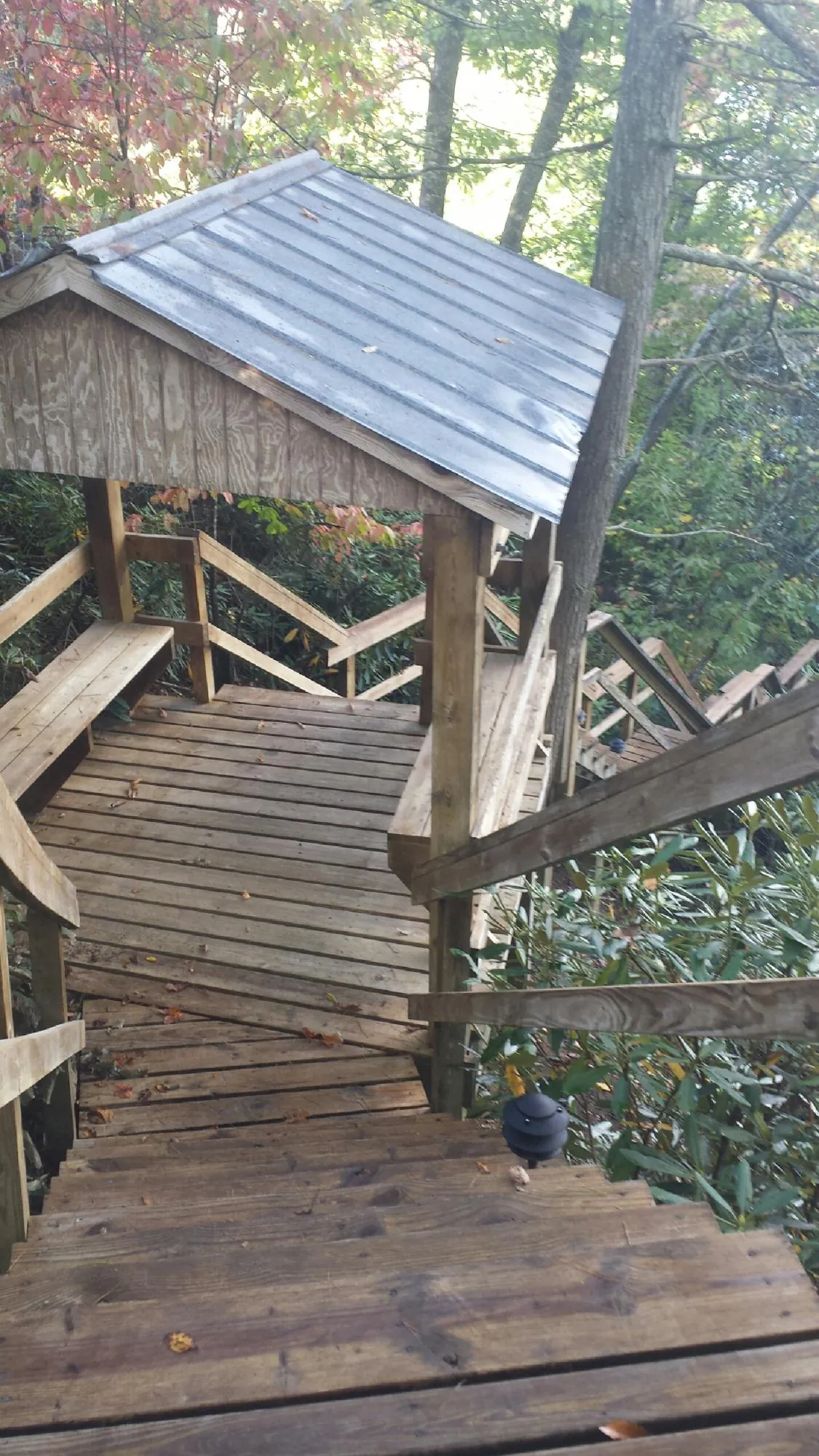 Metal roofed shelter over wooden steps on a wooded walkway — Skylight Repair & Installation work by our crew in Pottstown