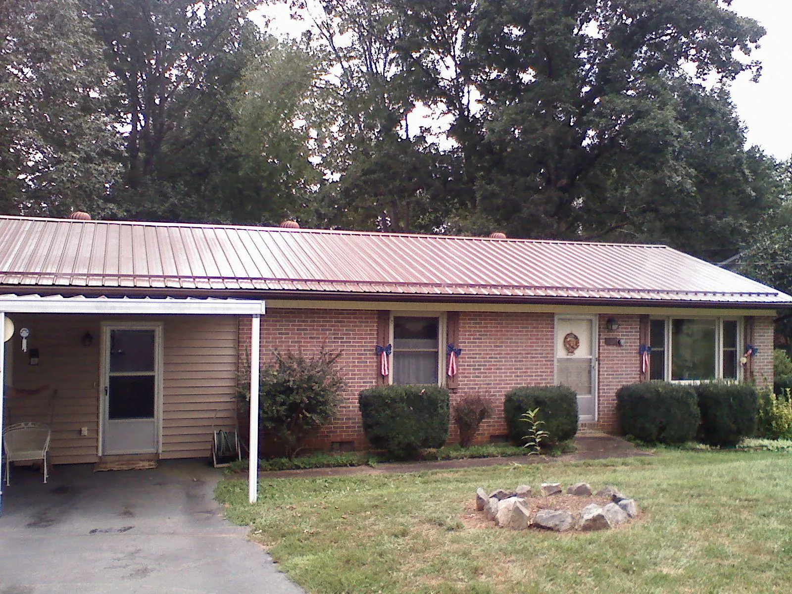 Bronze metal roof and carport on a brick ranch home — Roof Repair work by our crew in Pottstown